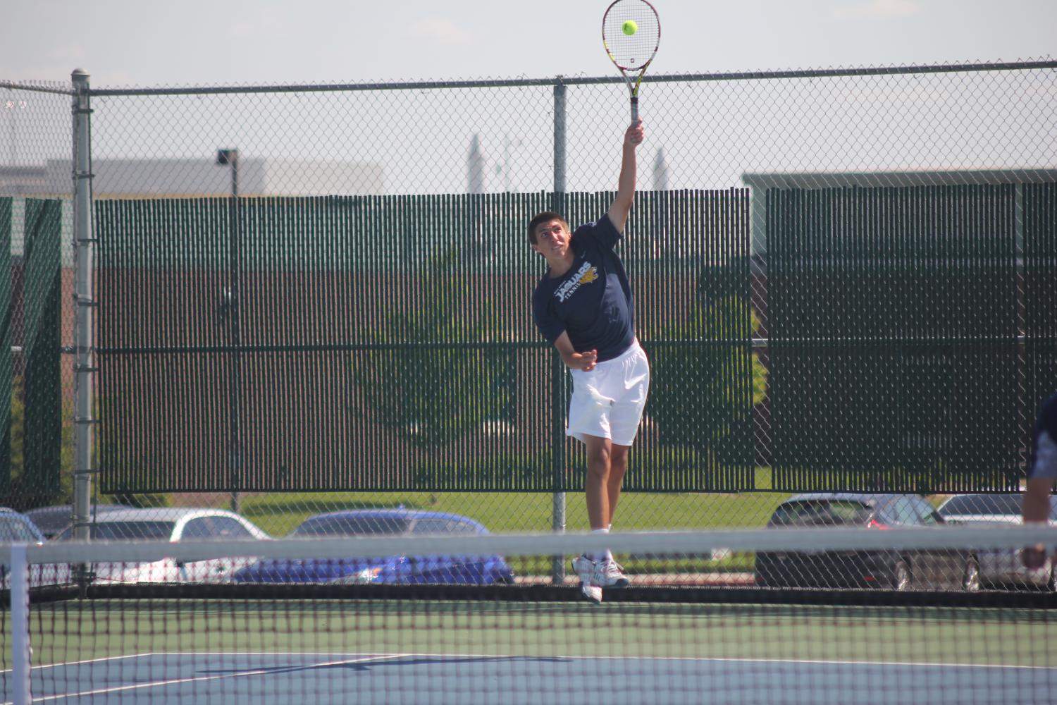 Senior Andrew Bock serves the ball. 