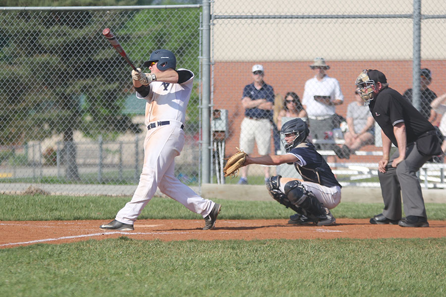 Keeping his eye on the ball, senior Brady Garrison swings the bat. 