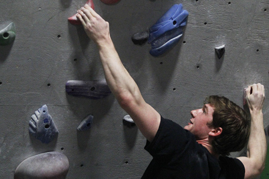 Gripping the handhold, senior Nick Nelson climbs at Apex Climbing Gym on Thursday, April 20.