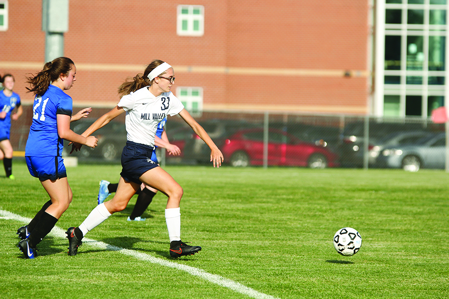 Sprinting past defenders and heading towards the goal, junior Erin Olson attempts to score.