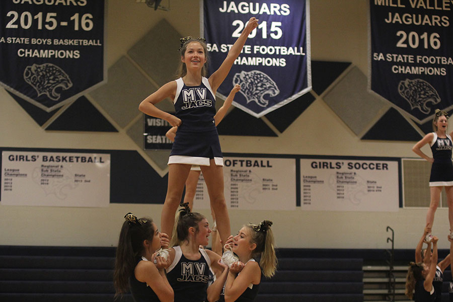 While in a stunt, freshman Allison Pham performs with the cheer team during the opening pep assembly. 