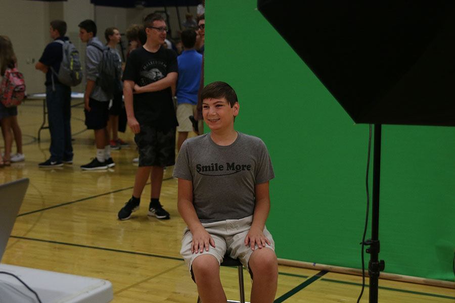 Before the start of orientation, a freshman smiles for his yearbook picture.