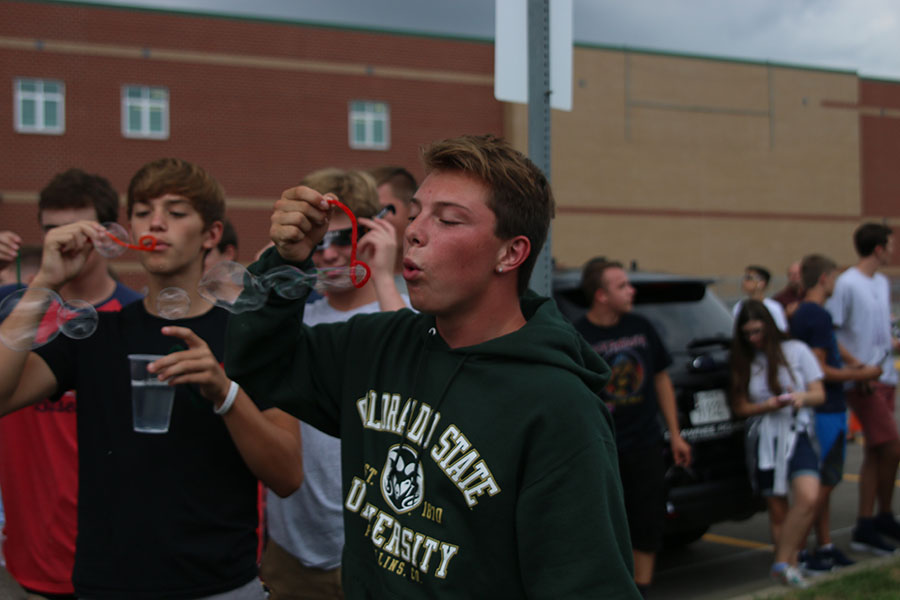 While waiting for the eclipse, junior Jack Matchette blows bubbles with classmates.
