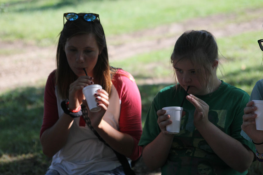 Sophomore Maria McElwee and junior Madi Reishus both enjoy a cup of frozen apple juice.