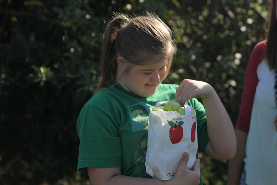 Sophomore Maria McElwee admires her bag full of apples.