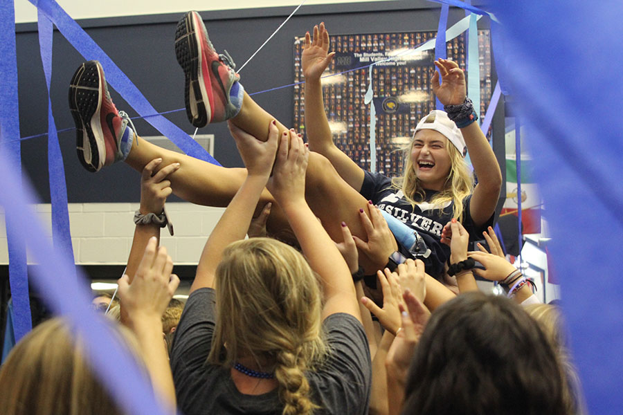 Holding up her arms, senior Bella Hadden crowd surfs during the blue bomb on Friday, September 8.