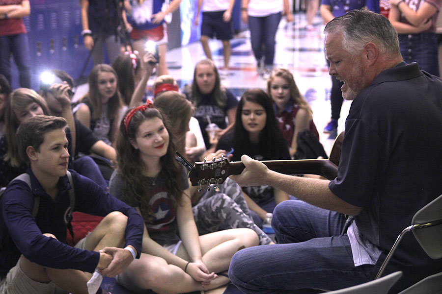 Students gather around Physics teacher Chad Brown as he performs .