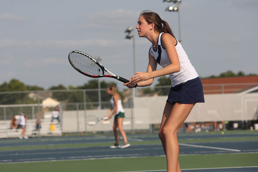 Preparing to hit the ball, freshman Sophie Lecuru plays at the home varsity tennis meet on Thursday Aug. 31.