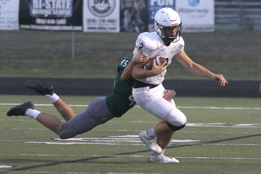 The Jaguars pulled out a win against Blue Valley Southwest 51-26 on Friday, Sept. 15. With a defensive player holding onto him, senior Brody Flaming attempts to gain yards. 