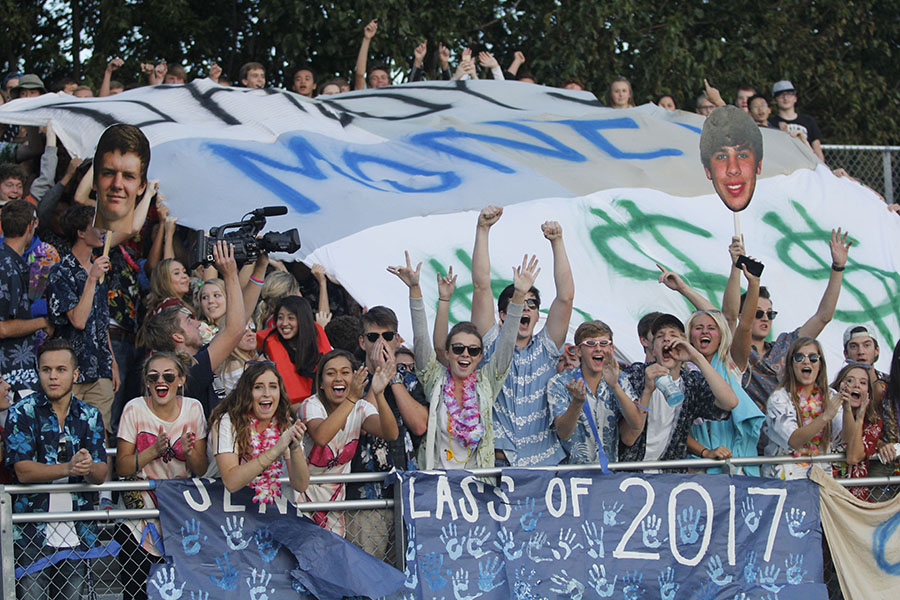 Dressed in tropical themed attire, students cheer as the football team competes against St. Thomas Aquinas on Friday, Sept. 30, 2016.