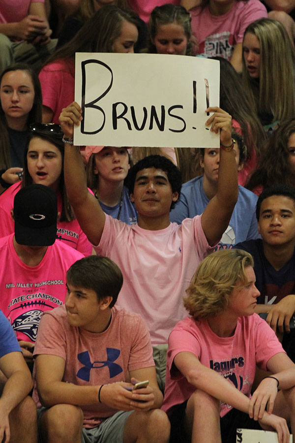 Junior Johnathan Contreras holds up a sign for one of the line judges, former middle school science teacher Roger Bruns.