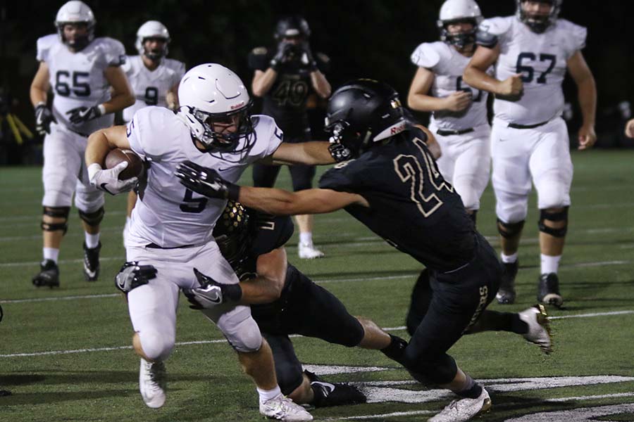 Holding out his hand, junior Logan Tally faces off with defensive players from BV.