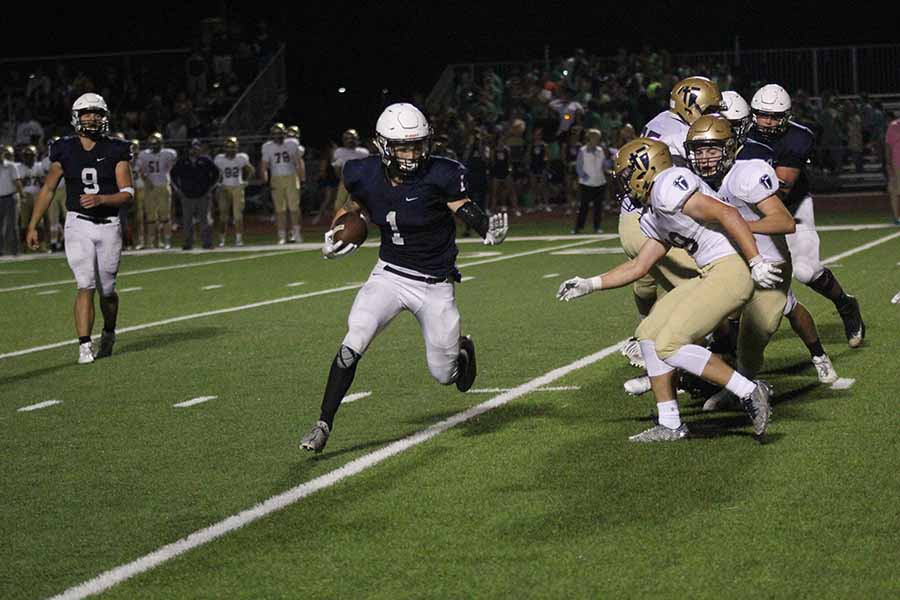 Avoiding members of the opposing team, junior running back Cameron Young runs downfield. 