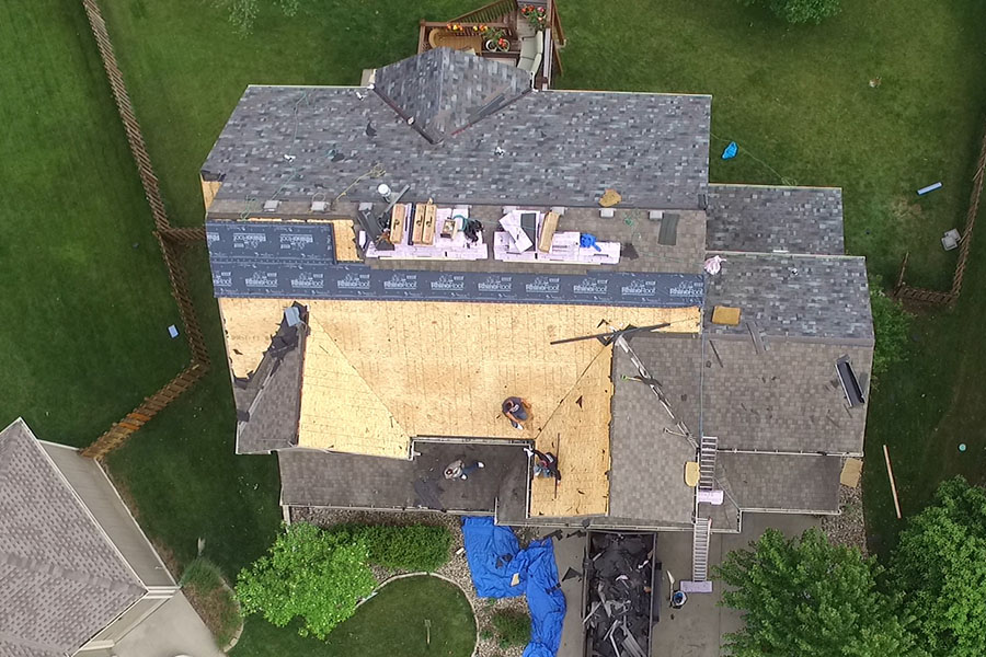 After major storms on Thursday, Mar. 9 workers replace the roof on a student's house on Wednesday, May 24.