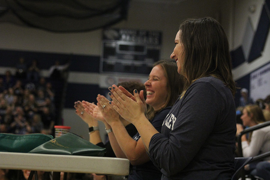 Judging the trash bag fashion show, art teacher Erica Crist claps.