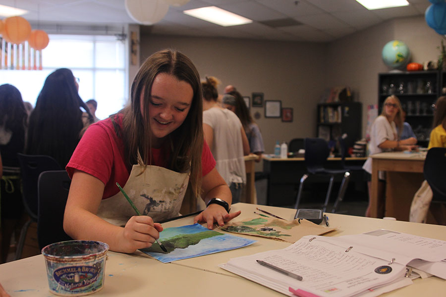Freshman Madison Larson smiles as she finishes her version of painter Bob Ross' "Mountain View" on Thursday, Sept. 14.