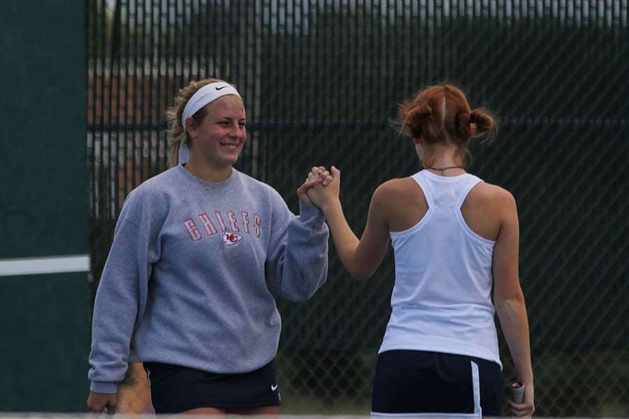 After winning the rally, senior Peyton Moeder high-fives her teammate, junior Josie Carey.