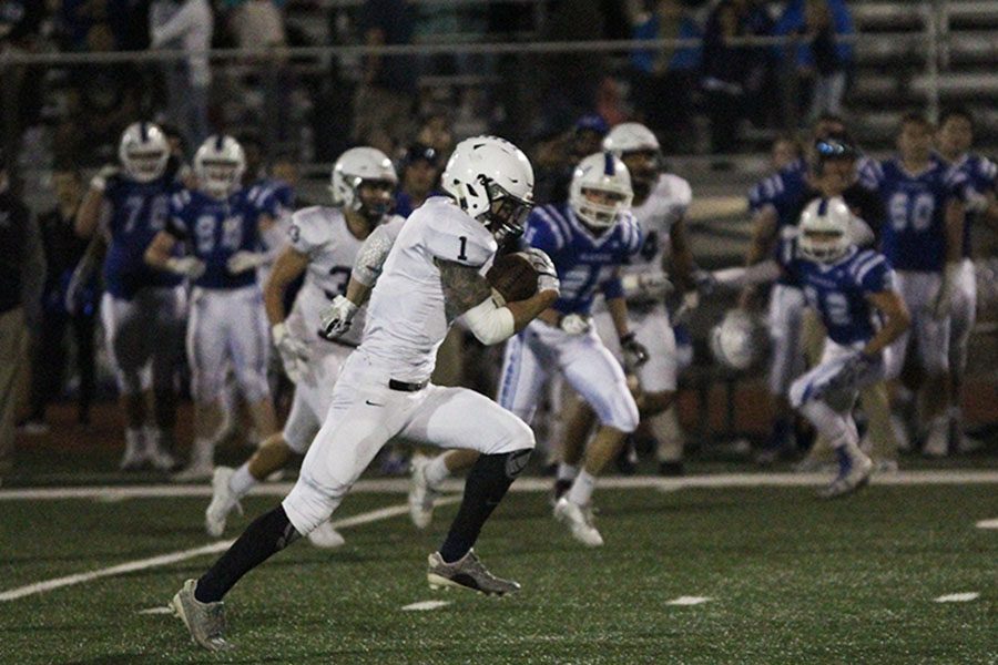 Before scoring a touchdown, junior Cameron Young runs the ball up the field.