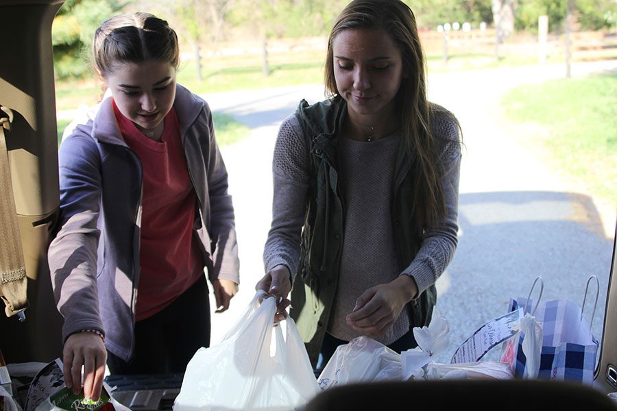 Participating in Trick-or-Treat-So-Others-Can-Eat on Monday Oct. 30, senior Hailey Stelle puts food into the trunk.