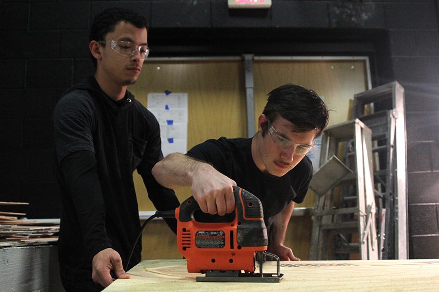 Using the jigsaw, seniors Jayden Moore and Julian Velez focus on cutting out set pieces on Friday, Sept. 29. “After you take the safety quiz,” Moore said. “Everybody starts building and using jigsaws and screwdrivers.”