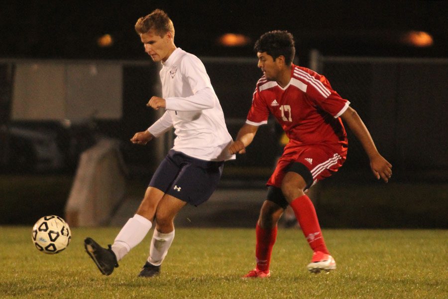 Junior Caleb Brown kicks the ball past a defender.