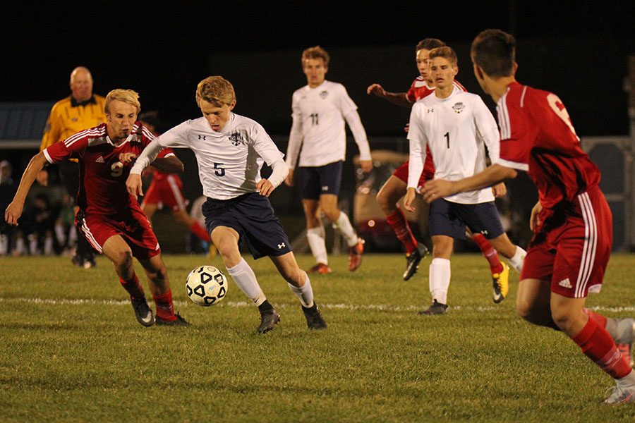 Fending off his opponent, sophomore Ian Carrol takes the ball down the field looking to score.