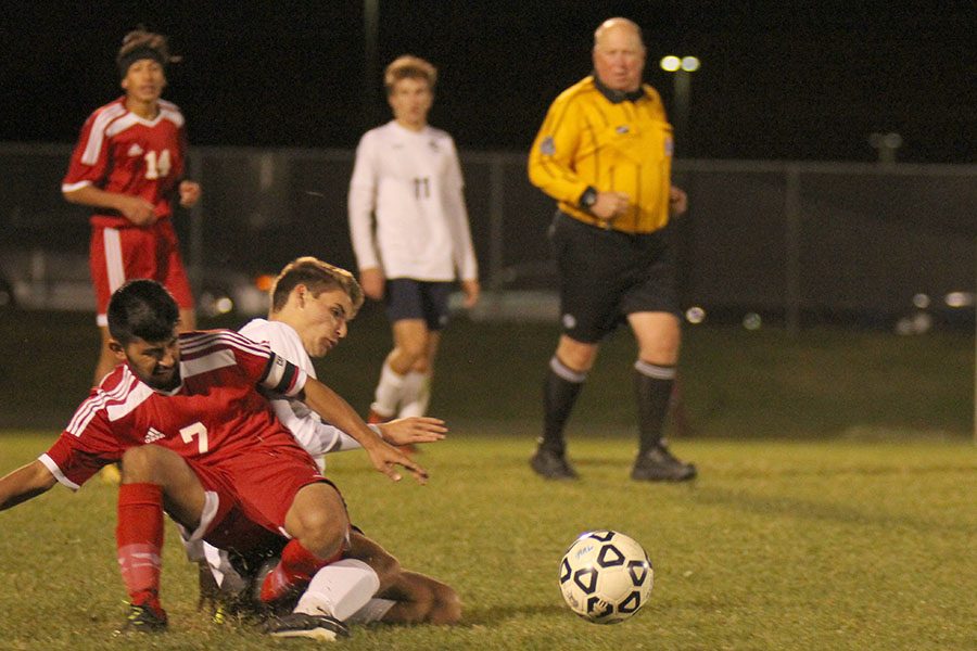 Sliding towards the ball, junior Caleb Brown takes an opposing player down with him.