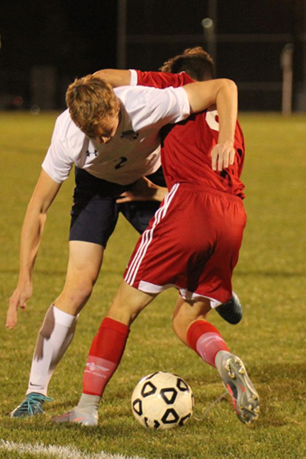 Senior Isaac Knapp and an opposing player battle over possession of the ball. 