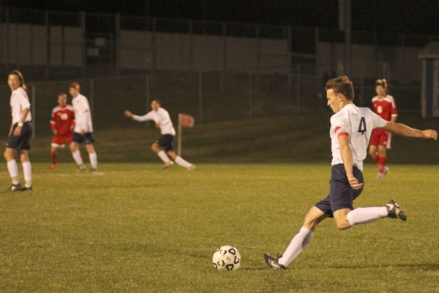Bringing his leg back, senior Kyle Franklin begins to pass the ball to a teammate.