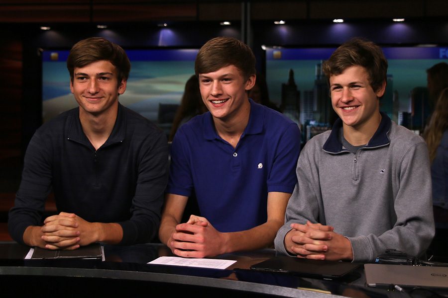 While visiting the Fox 4 News studio, sophomore Riley Ferguson, and juniors Blake Aerni and Noah Smith sit behind the news desk in Studio A on Tuesday, Oct. 24.