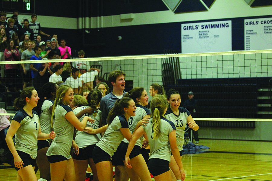 Looking at the scorboard on Thursday, Oct. 5, junior Joe Cosmillo celebrates with the varsity volleyball team after their win against Lansing. It was a lot of fun to be involved with such a closeknit team when I started managing and helping out, Cosmillo said.