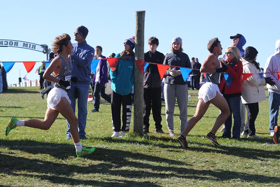 Running after each other, seniors Tyler Coad and Justin Grega pass by fans and spectators.