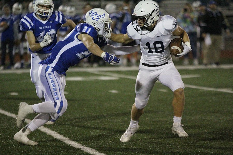 Running away from a member of the opposing team, senior Evan Rice stiff arms a defender on Friday, Oct. 20 against Gardner-Edgerton, leading the Jaguars to a 35-21 victory.