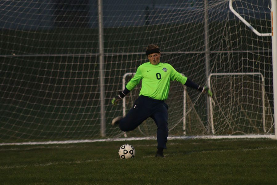 Approaching the edge of the goal, junior Aidan Veal lifts his foot back to powerfully kick the ball down the field. 