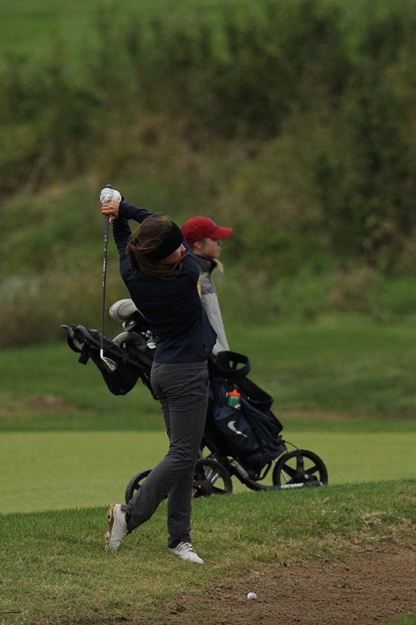 Before hitting the ball, Junior Sarah Lawson takes some practice swings to focus on her strategy. 