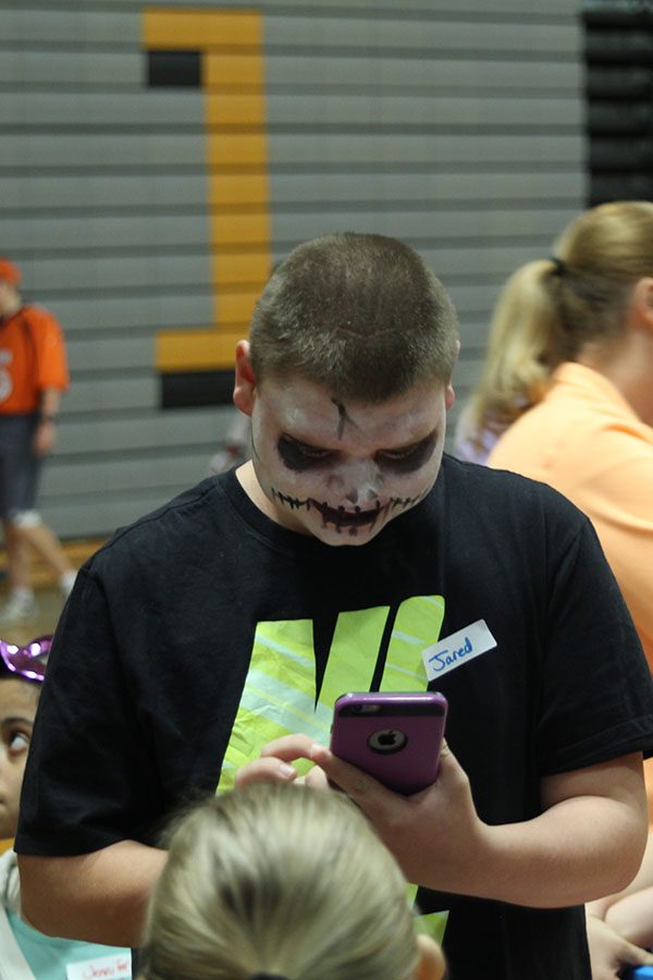 Looking at his painted face, sophomore Jared Brehaney participates at the halloween party at Basehor-Linwood High School on Monday,Oct.30.