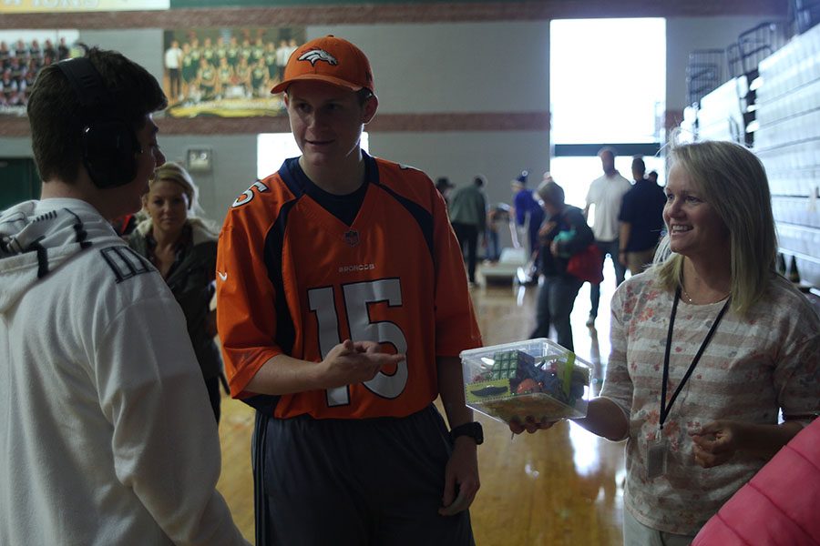 Junior Zachary Dixon helps Junior Ben Schamberger guess how many items are in the box. 