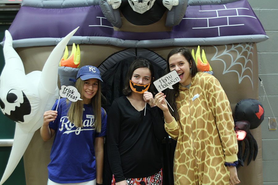 Posing at the photo booth, juniors Trinity Knapp, Janelle Tomandl and Karsyn Aylward smile at the camera. 