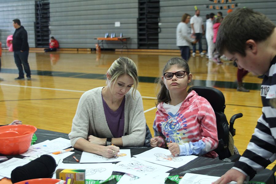 Junior Corinne Brown looks at other students art work during the Halloween party on Monday, Oct. 30.