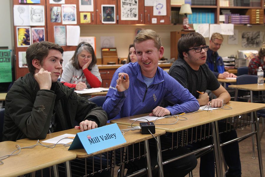 After getting the correct answer, senior Landon Butler smiles at his teammates during the Quiz Bowl meet at Eudora High School on Wednesday, Nov. 15. 