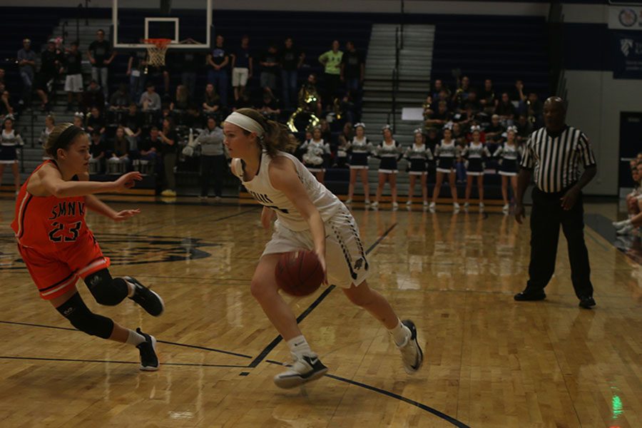 With her defender in close pursuit, junior Claire Kaifes drives from outside the three point line.