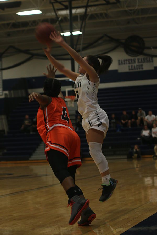 After receiving a pass from a teammate, junior Presley Barton shoots a three pointer over her defender.