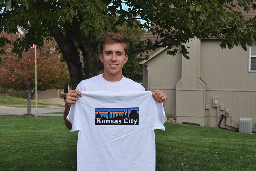 Senior Nolan LaBarge holds up one of the two products that he sells from his company Kansagonia. LaBarge has encountered several difficulties while starting up his business. “Dont put [the stickers] on a car because they are not weather-proof,” LaBarge said. “I learned that the hard way.”
