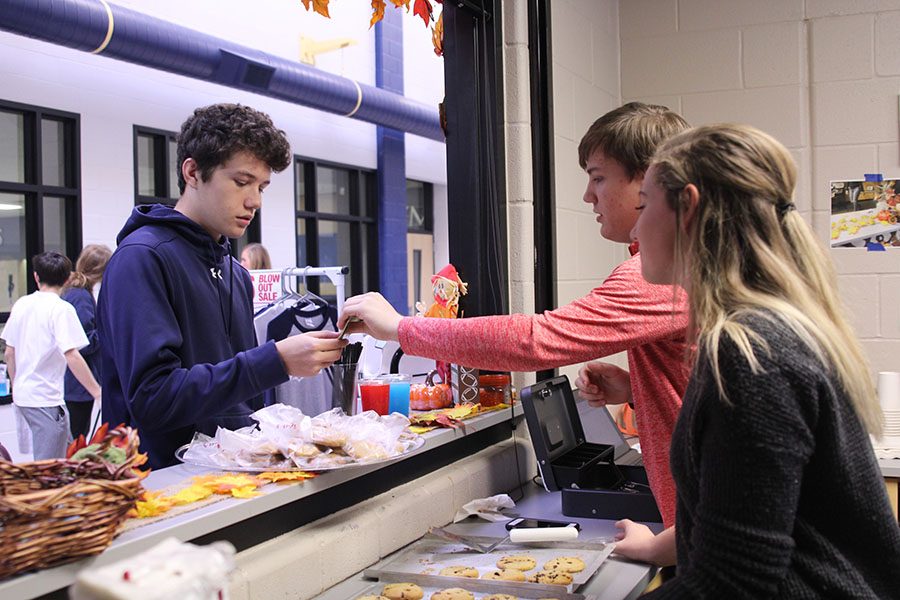 After junior T.J. Smith buys a freshly-baked cookie on Thursday, Nov. 16, senior John States hands back the change. 