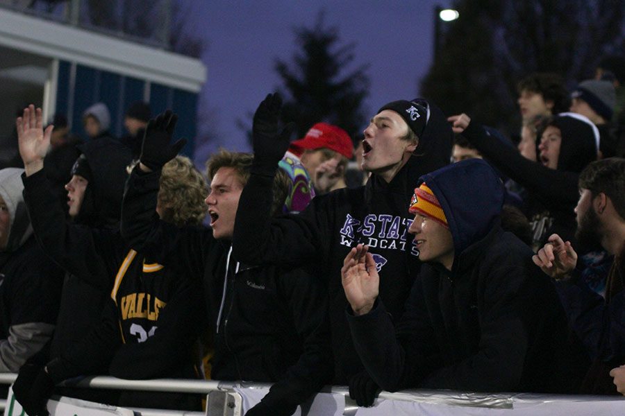 Seniors Conner Ward and Ben Weigel encourage the soccer team as they get to the end of the game.