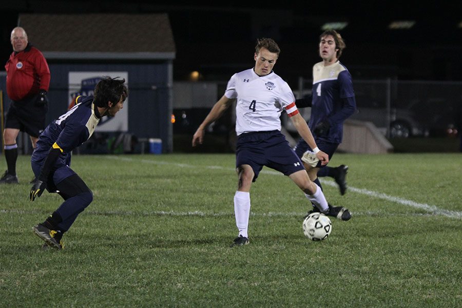 Avoiding Aquinas players, senior Kyle Franklin kicks the ball in the opposite direction.