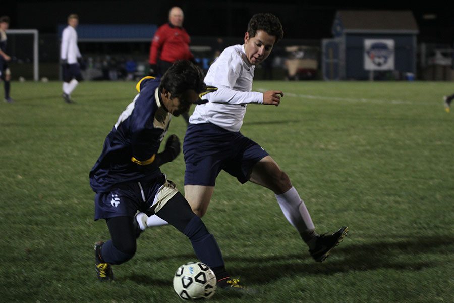 Junior Ricardo Araujo tries to win the ball from an aquinas player.