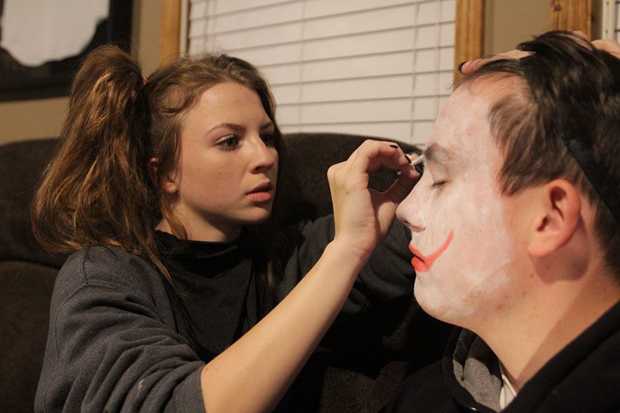 Putting makeup on senior Garrett Mehners face, senior Chandler Randolph prepares for the haunted house at senior Preston Cole’s house on Monday, Oct. 30. “To get ready for the [haunted house] we just had to put on our clown makeup on while others had to put on their costumes,” Mehner said. “I loved when I sacred this [girl] so bad that she peed her pants.”