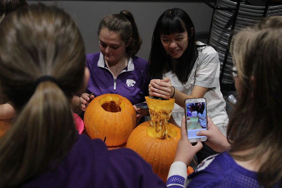 Pulling the top of a pumpkin, senior Chin-Yun Hsu lifts the guts of the pumpkin out at the at the Westside Family Church pumpkin party.