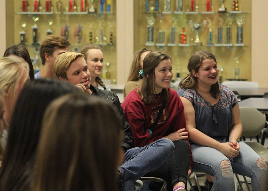 Watching as a peer performs, junior Annie Myers listens and smiles. 